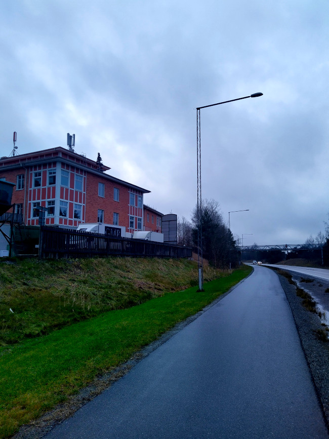 En hjulgran på ett hustak vid en väg